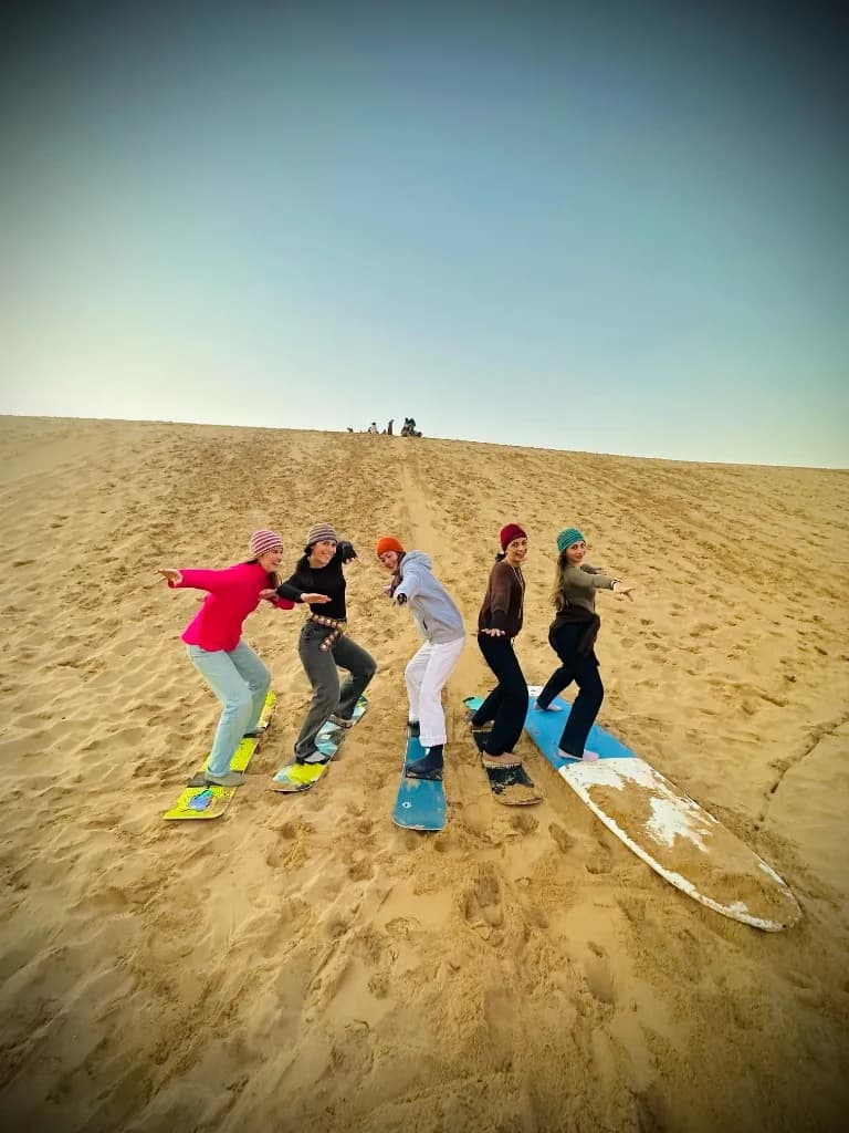 Group sandboarding on the Timlaline dunes near Agadir